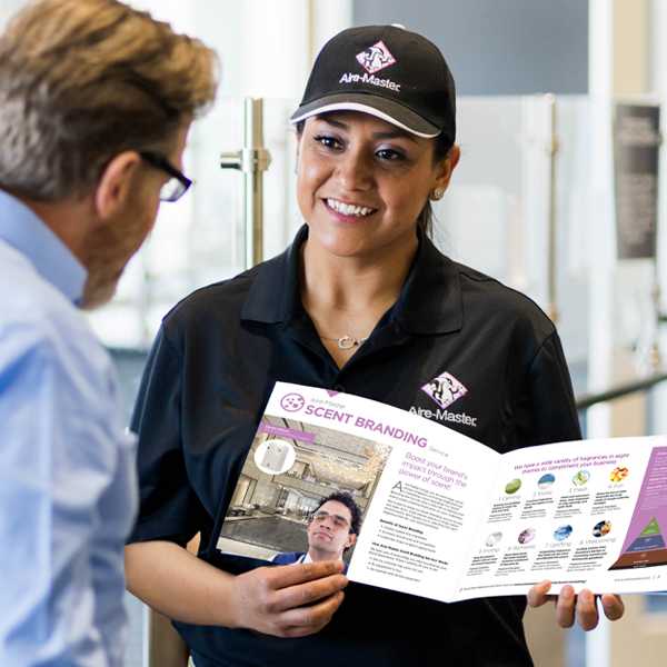 Aire-Master service representative holding catalog and talking with customer
